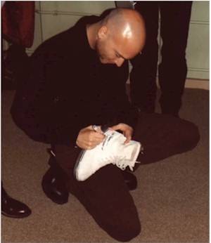 Michael signing shoes from Tommy